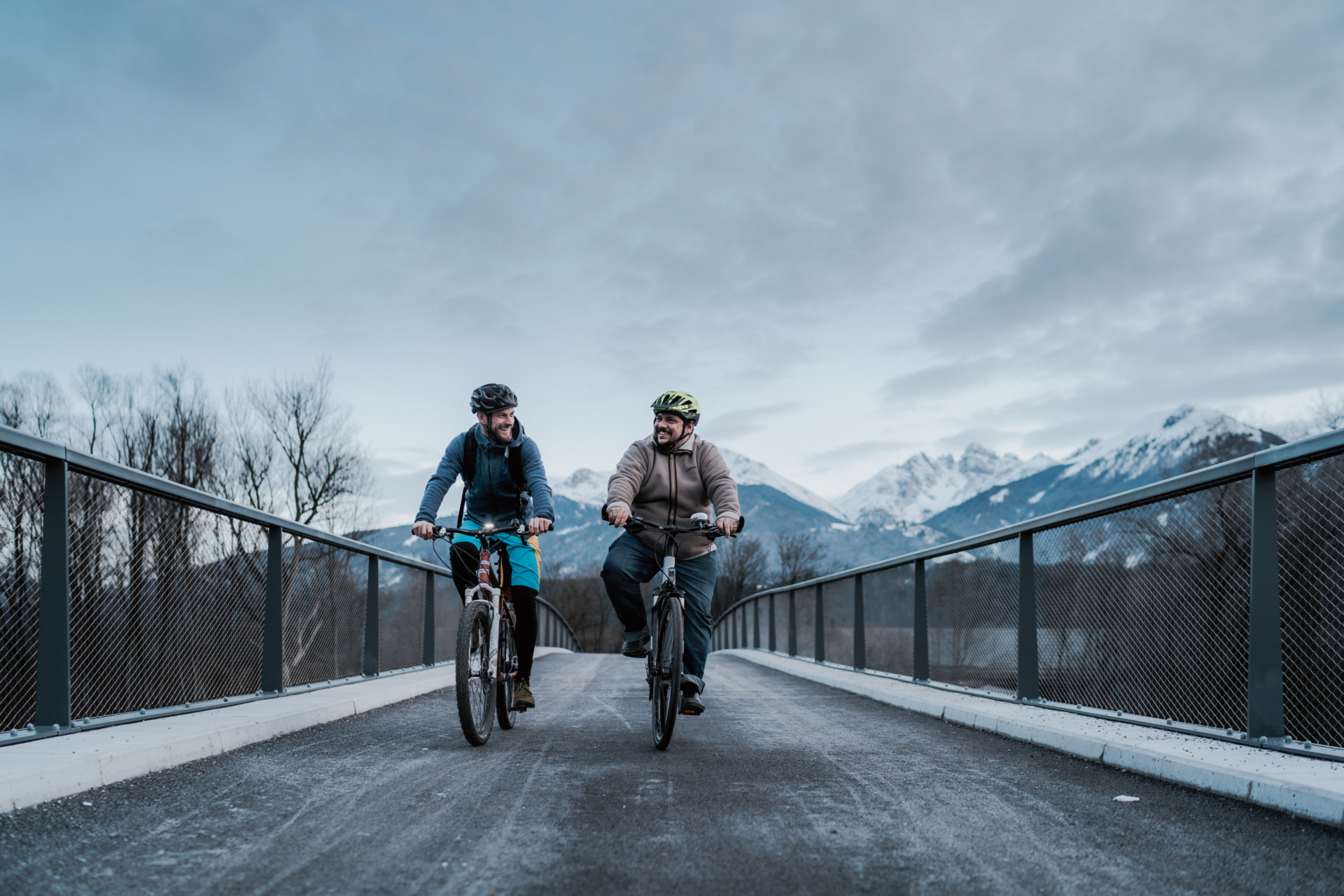 Zwei Männer fahren über Fahrrad Brücke mit Rad: