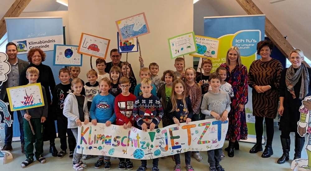 Klimaversum Eröffnung Markt Hartmannsdorf, Kinder einer Schulklasse halten Schild mit Spruch "Klimaschutz jetzt"