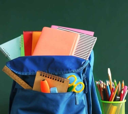 Bild von einer Schultasche mit Materialien, wie Stifte, Hefte und Scheren