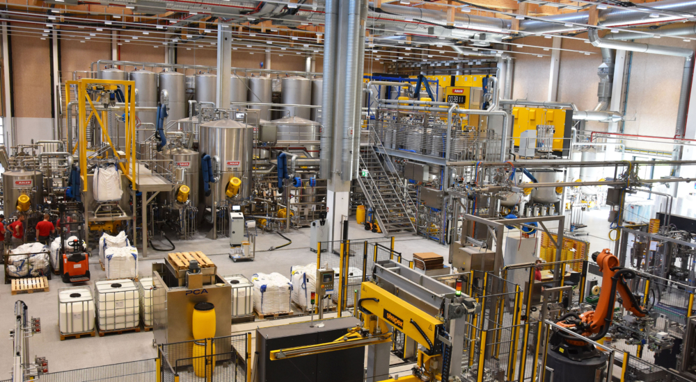 Produktionshalle mit Abfüllanlage und Palettierroboter der Adler Lackfabrik