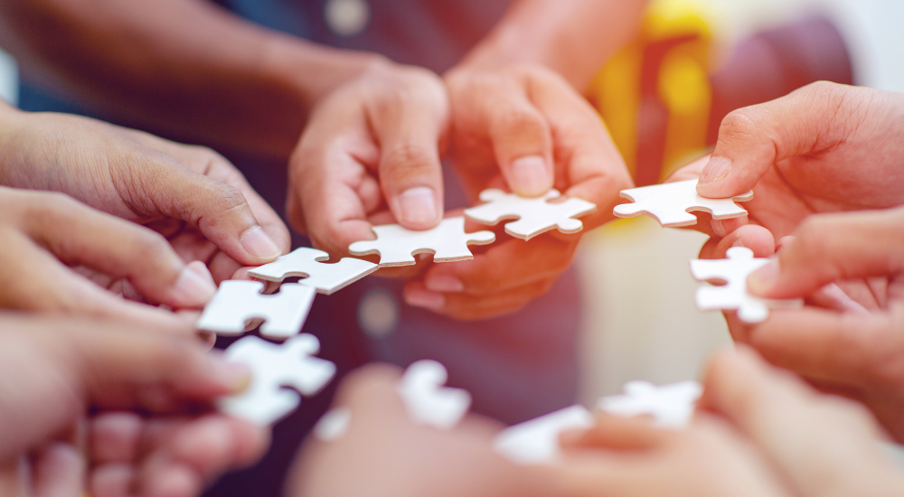 Menschen halten Puzzleteile
