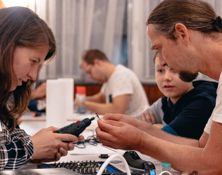 Eine Frau und ein Mann reparieren gemeinsam ein Elektrogerät.