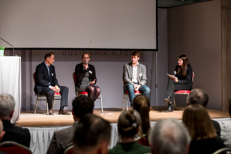 Vier Personen sitzen auf der Bühne und diskutieren über Klimaschutz.