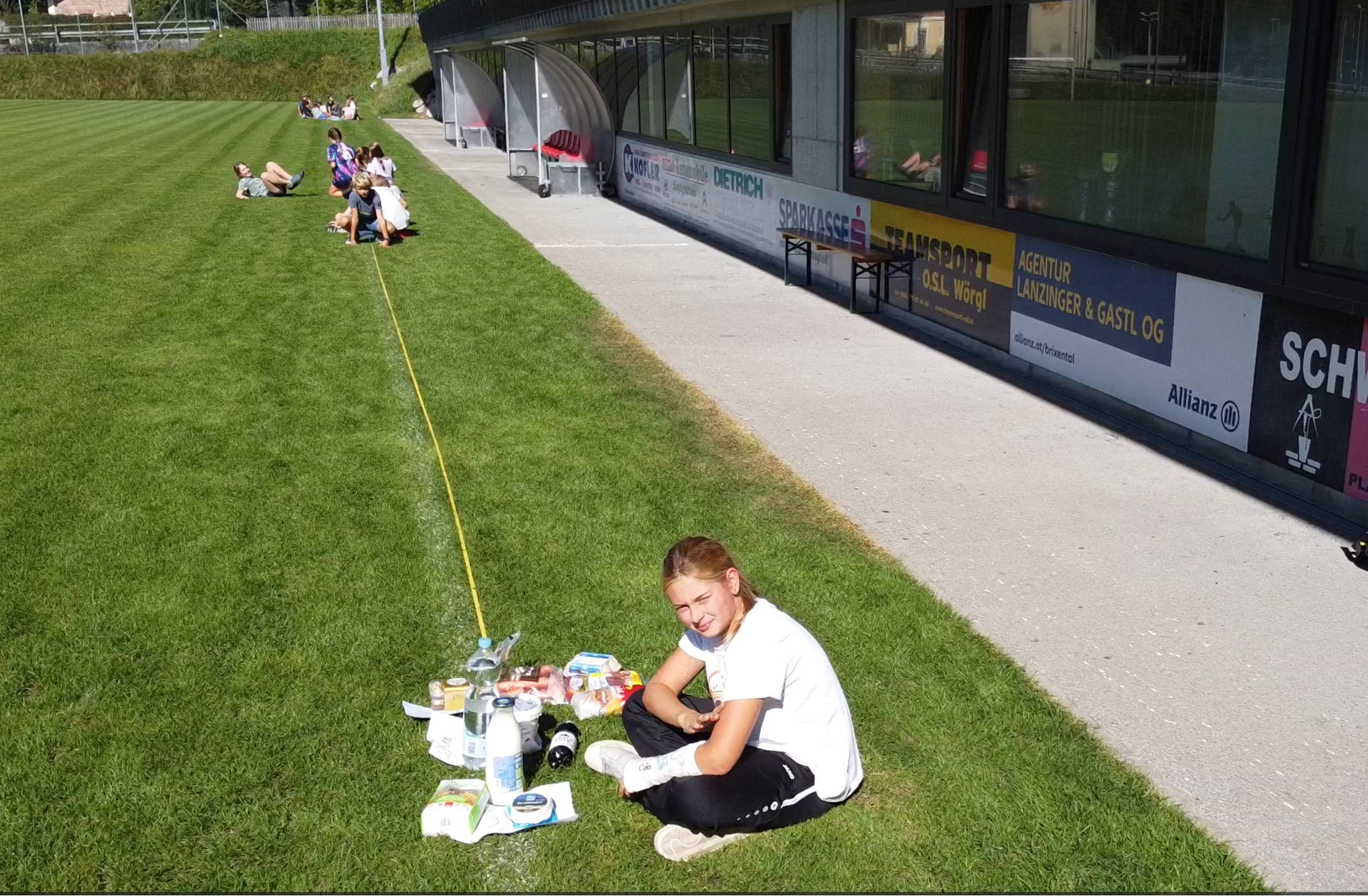 Kinder mit Maßband auf Fußballfeld