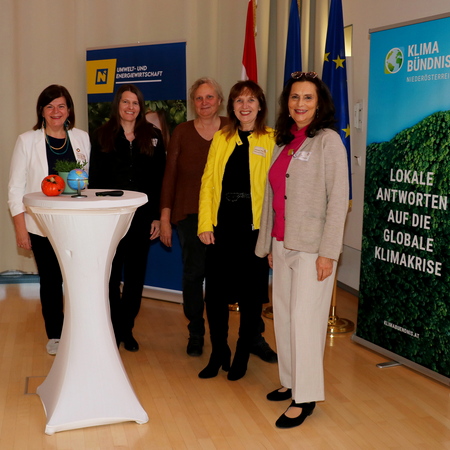 Fünf Frauen stehen vor einem Stehtisch.