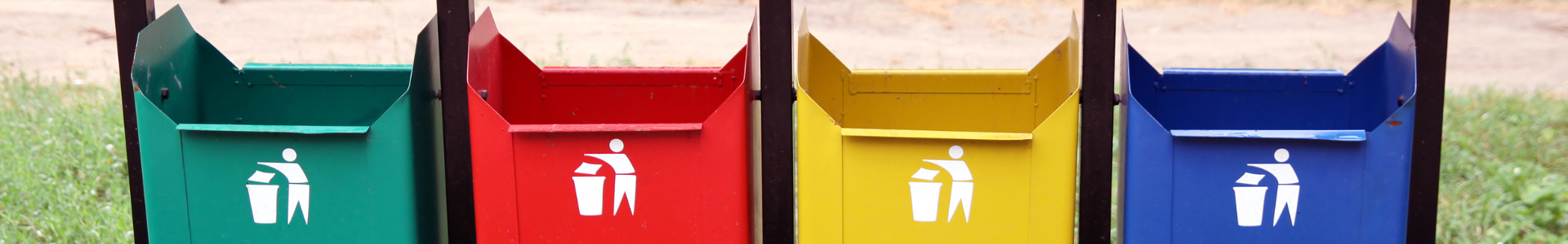 3 aufgehängte Mülleimer in den Farben grün, rot, gelb und blau