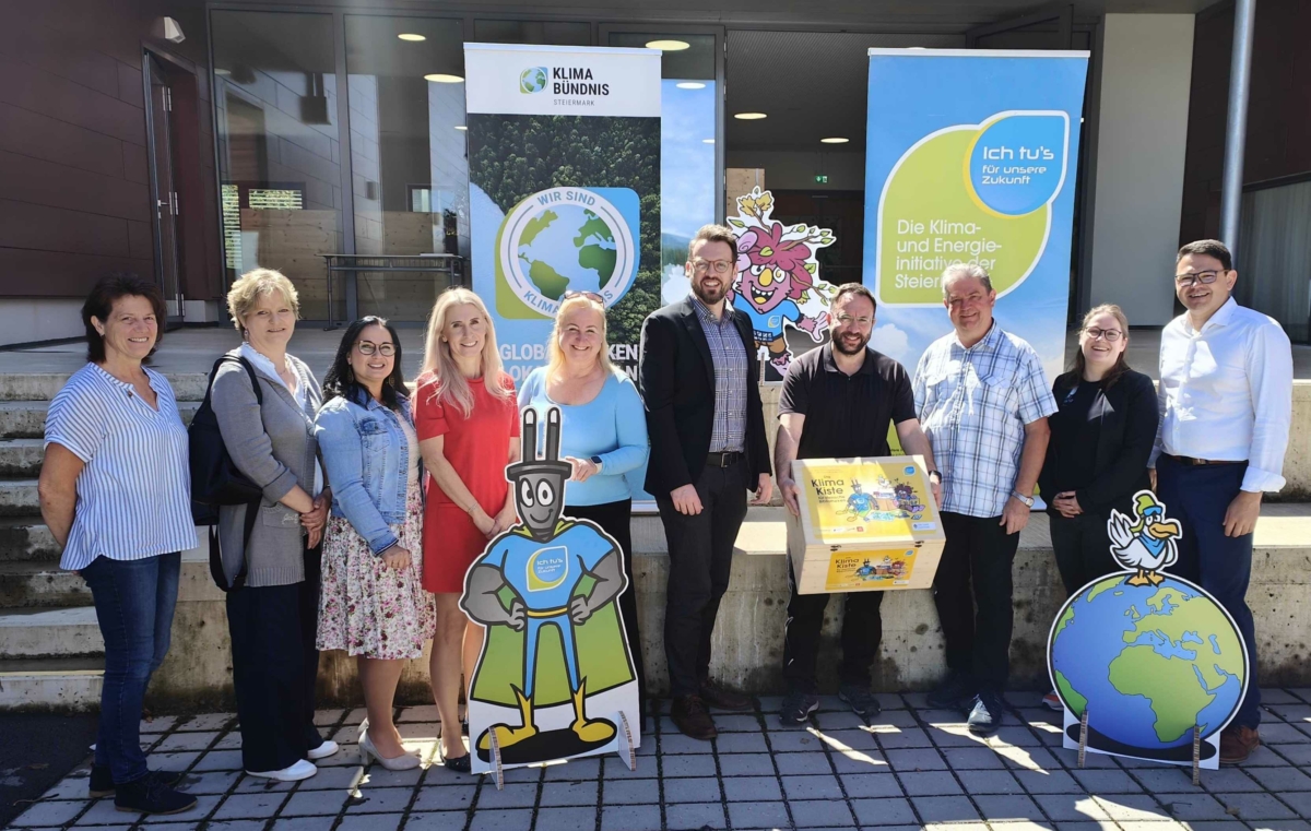 Gruppenfoto mit zwei Rollups im Hintegrund, eine Person hat die Holzkiste der Klimakiste in der Hand