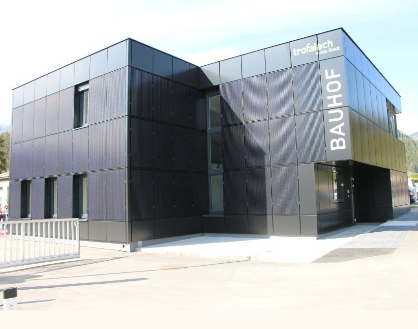 Schwarzes Gebäude mit Photovoltaik-Panelen an der Hauswand