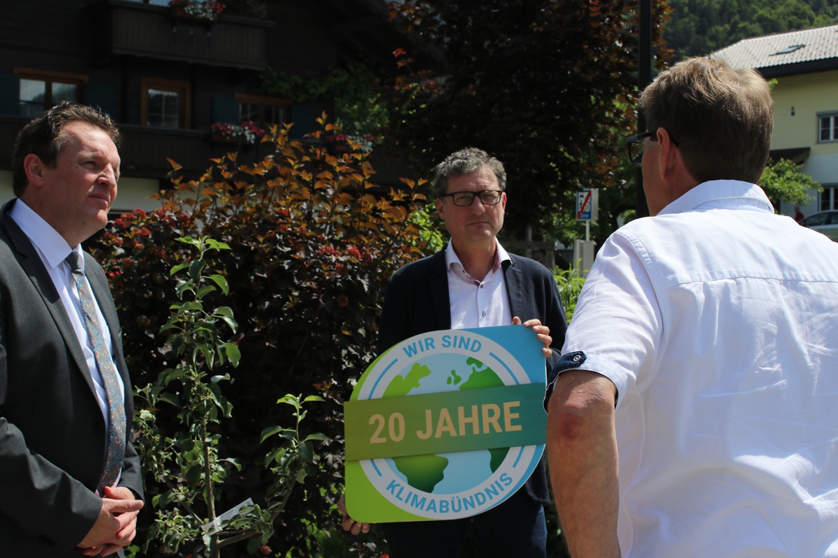 LR René Zumtobel und Klimabündnis Geschäftsführer Andrä Stigger überreichen Bürgermeister Ritzer einen Baum zum Jubiläum.