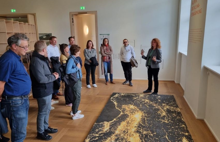 Menschen stehen vor Kunstwerk am Boden, Karte mit Lichtern